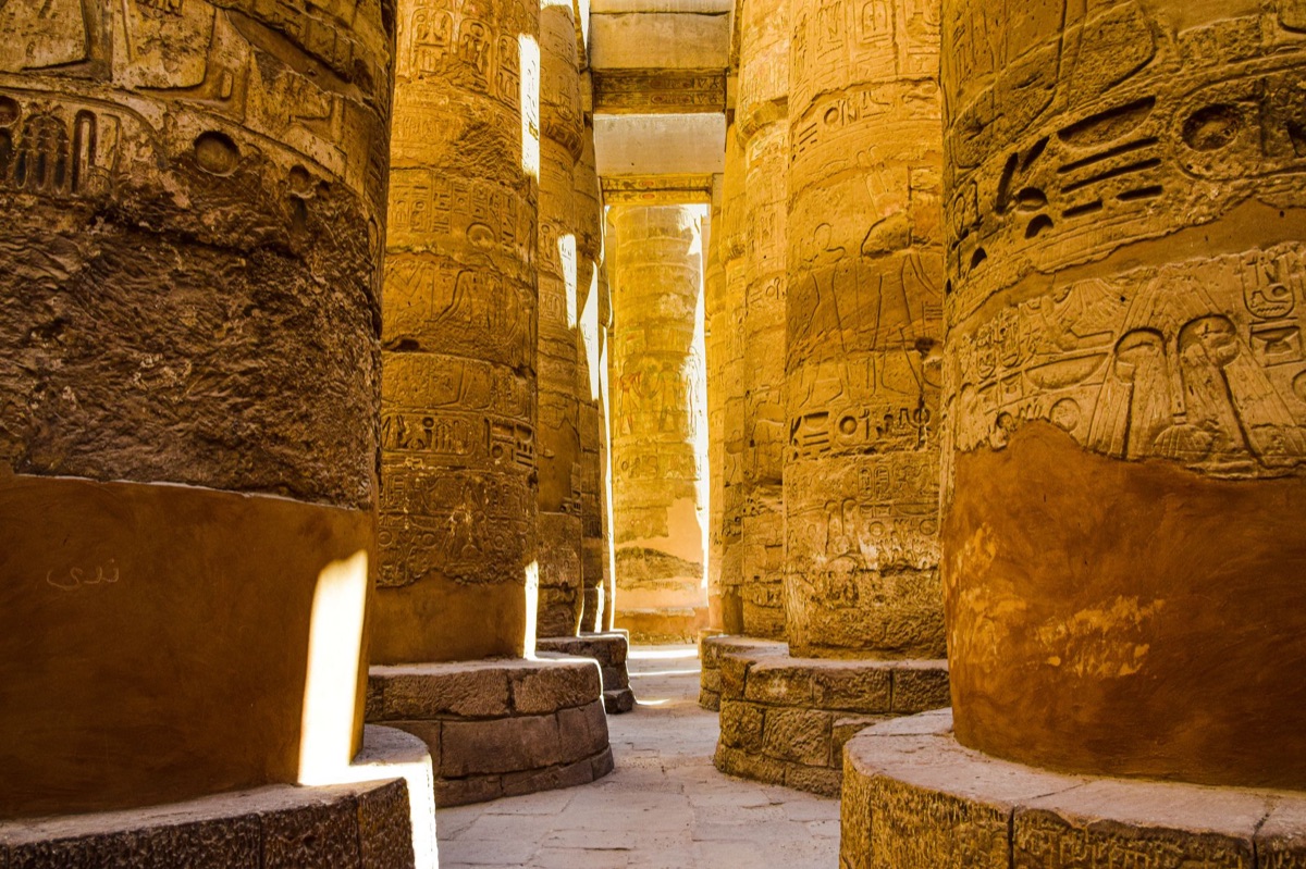 Karnak Temple facade with sun rays highlighting religious symbolism